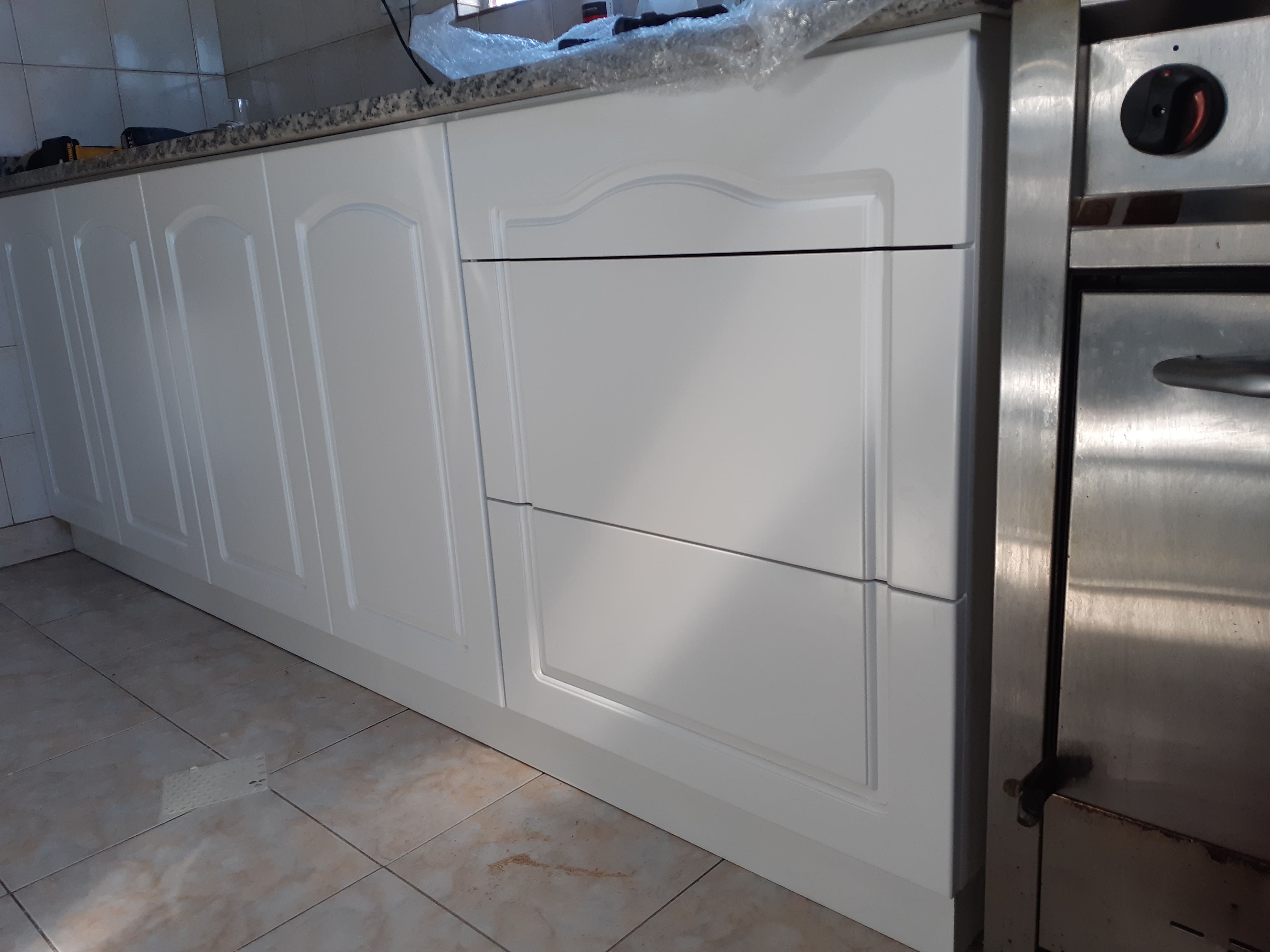 Cocina integral blanca con bajo mesada y horno empotrado