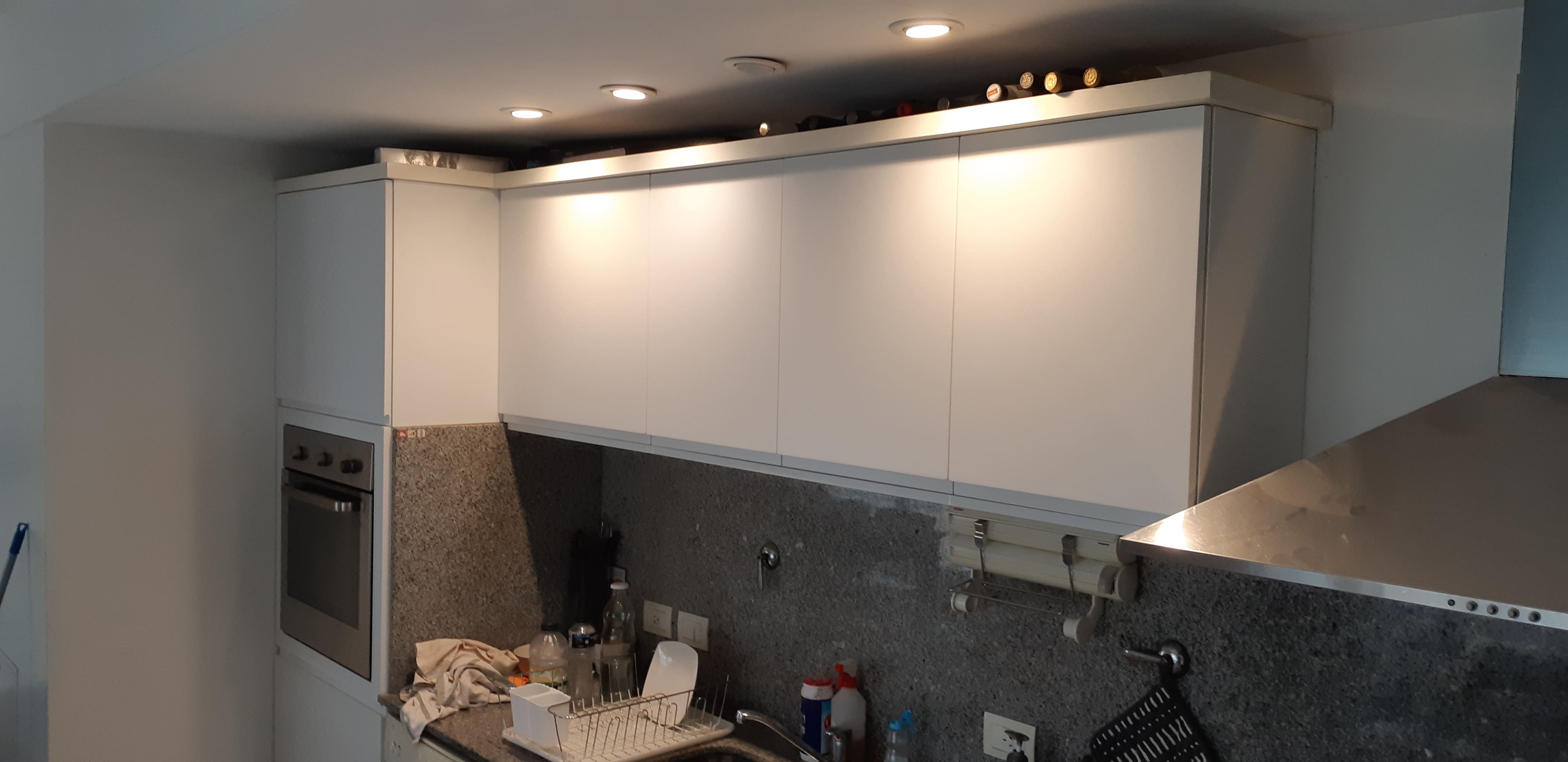 Isla de cocina con mesada de madera y estantes a medida